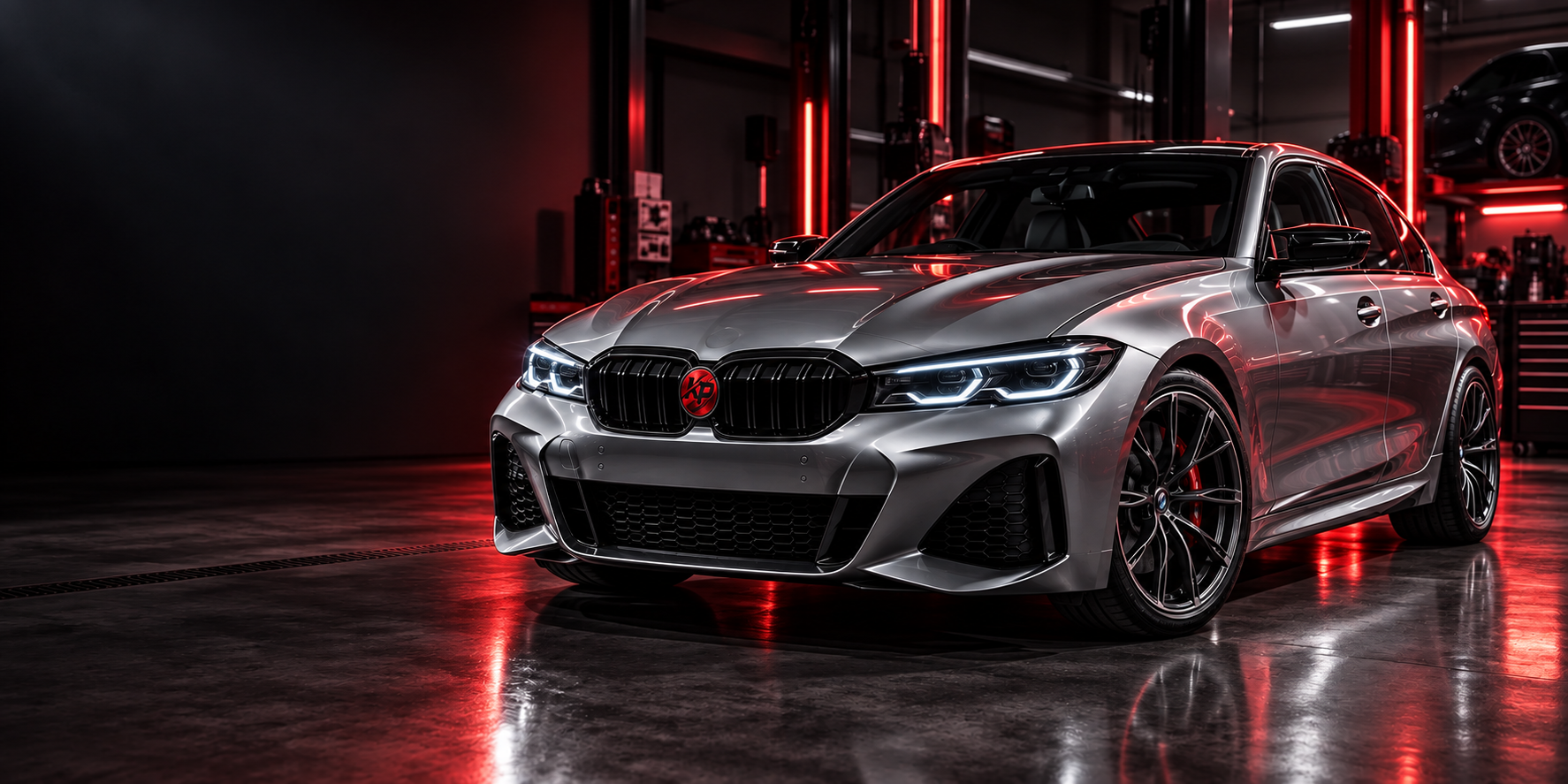 Silver sports saloon with a red KP grille badge in a workshop with red lighting